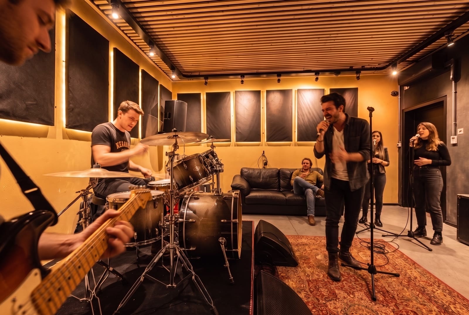 Een volledige band in jam met zanger en backingzangers in een ruimte van Temple Studios