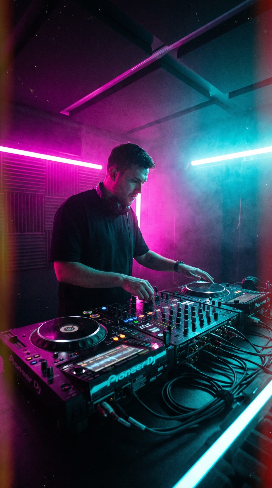 Pioneer CDJs and a DJM mixer in the neon-lit Studio 4 DJ booth in Mons